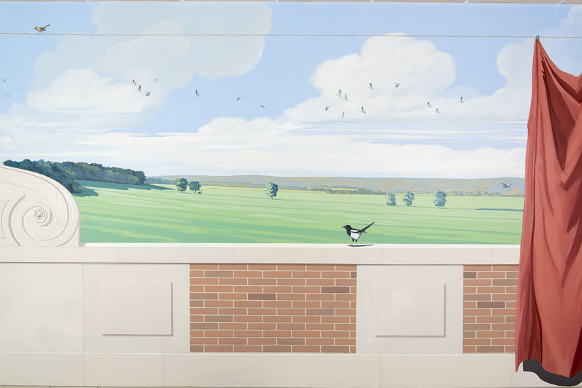 Détail du trompe l'oeil avec un bout de rideau et de ballustrade devant le paysage campagnard