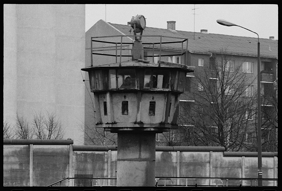 Photographie noir et blanc d'une tour de garde avec des immeubles en fond