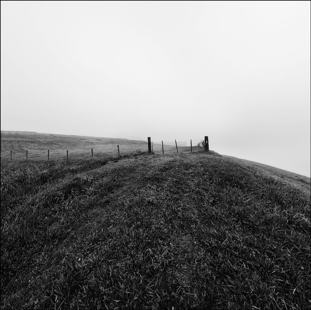 Photographie numérique et noir et blanc d'une barrière en bord de falaise