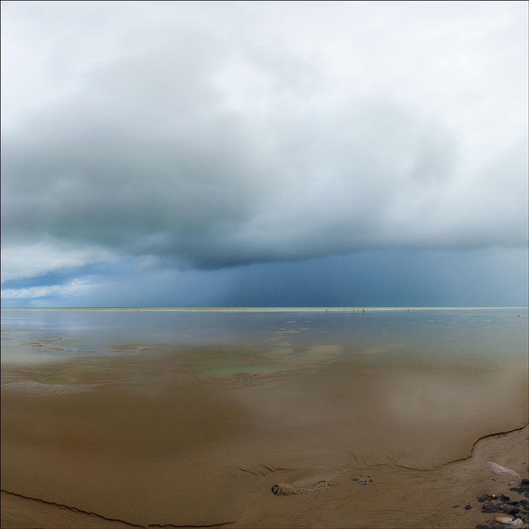 Photographie numérique en couleur d'une plage au sable lisse dirigé vers la mer