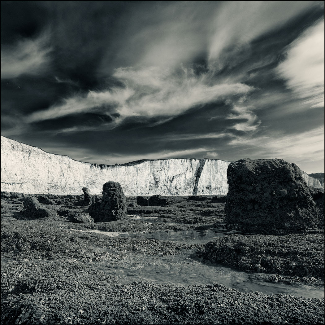 Photographie numérique avec la plage rocheuse en premier plan et la falaise en arrière plan