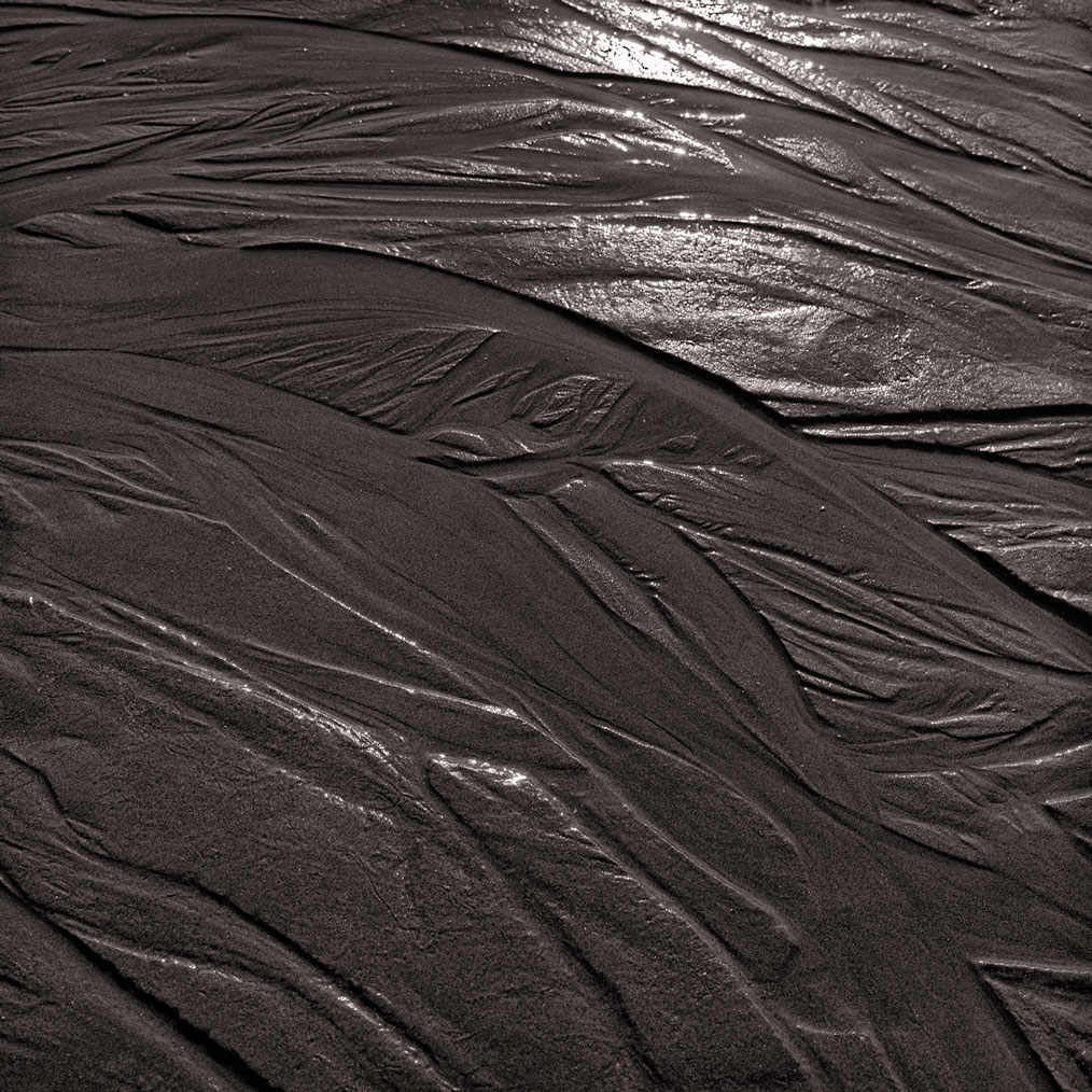 Photographie numérique du passage de l'eau dans le sable à marée basse