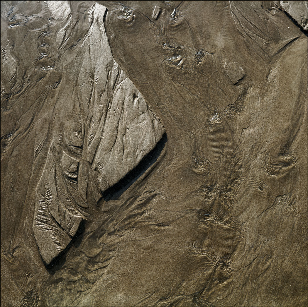 Photographie numérique tons sépia des marques laissées par l'eau dans le sable à Ault Onival